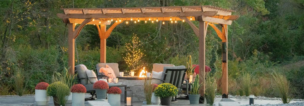 Pergola with outdoor seating and fire pit at dusk